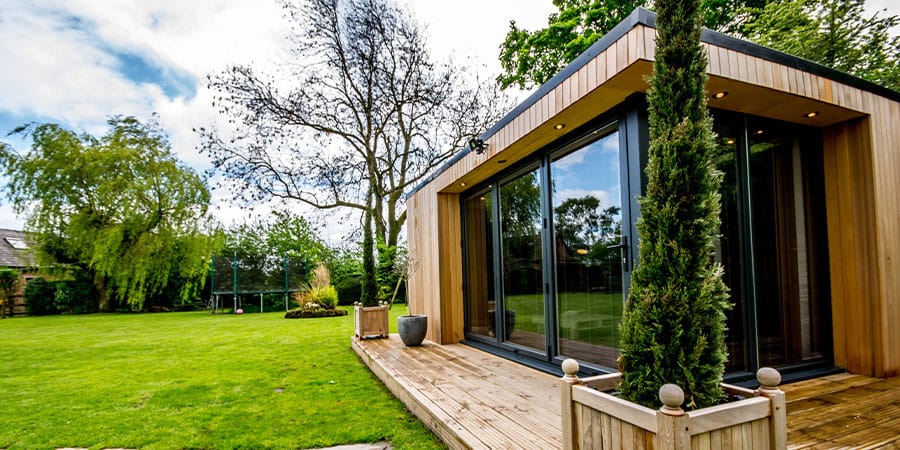Timber-clad garden room with glazed doors and a decked terrace