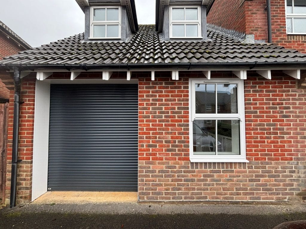 Brick house with a new roller shutter garage door and a driveway