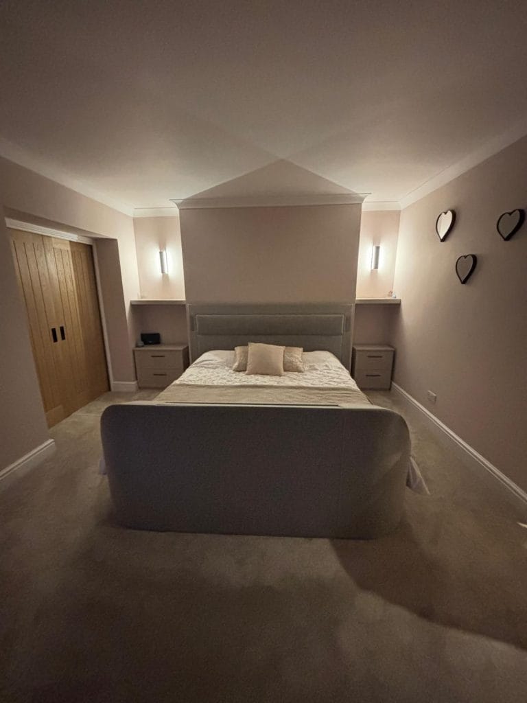 Bedroom with a fitted bed and wall lighting