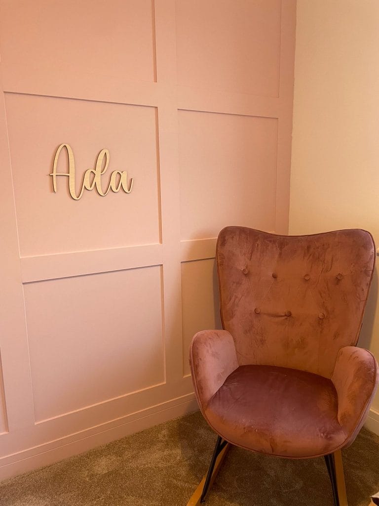 Corner of a room with panelled walls and an upholstered armchair